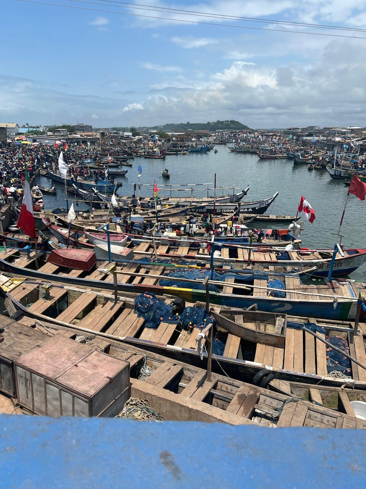 A view of the bustling Elmina fish market adjacent to the castle. This image captures the powerful contrast between the historic site of the dungeons and the vibrant, living energy of the local community today.